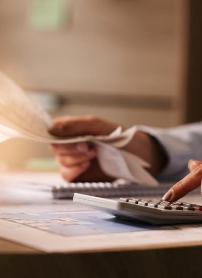 closeup-economist-using-calculator-while-going-through-bills-taxes-office